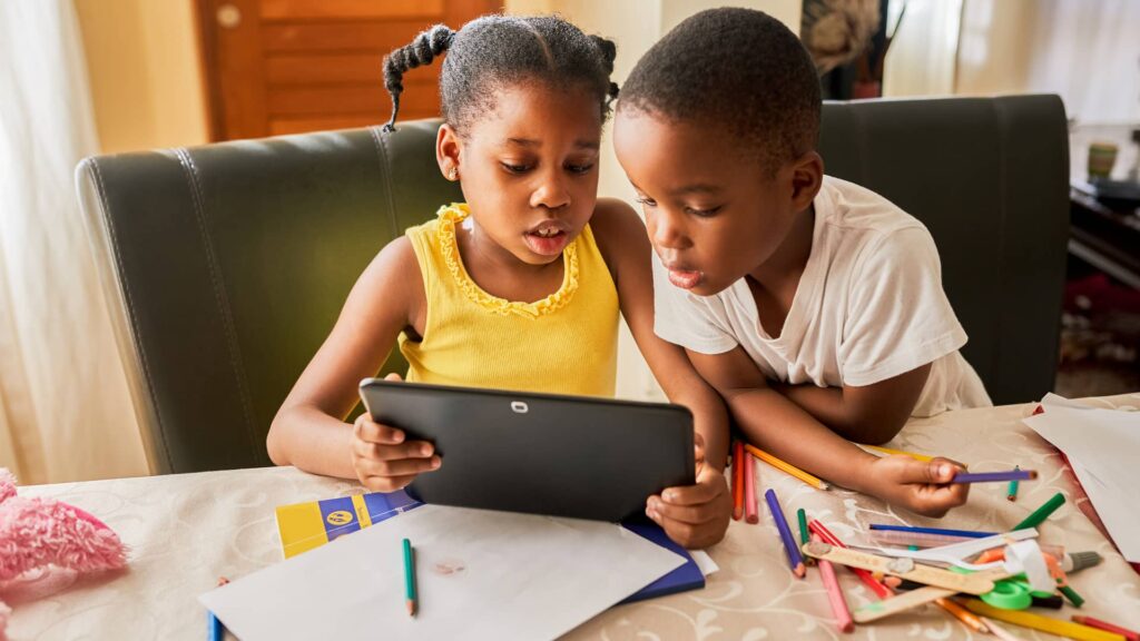 Dos niños , estudiando en un ordenador portatil
