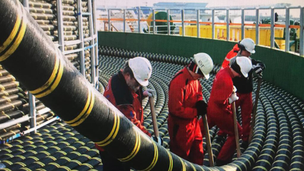 Obreros preparando cable submarino en el barco para su instalación en el mar